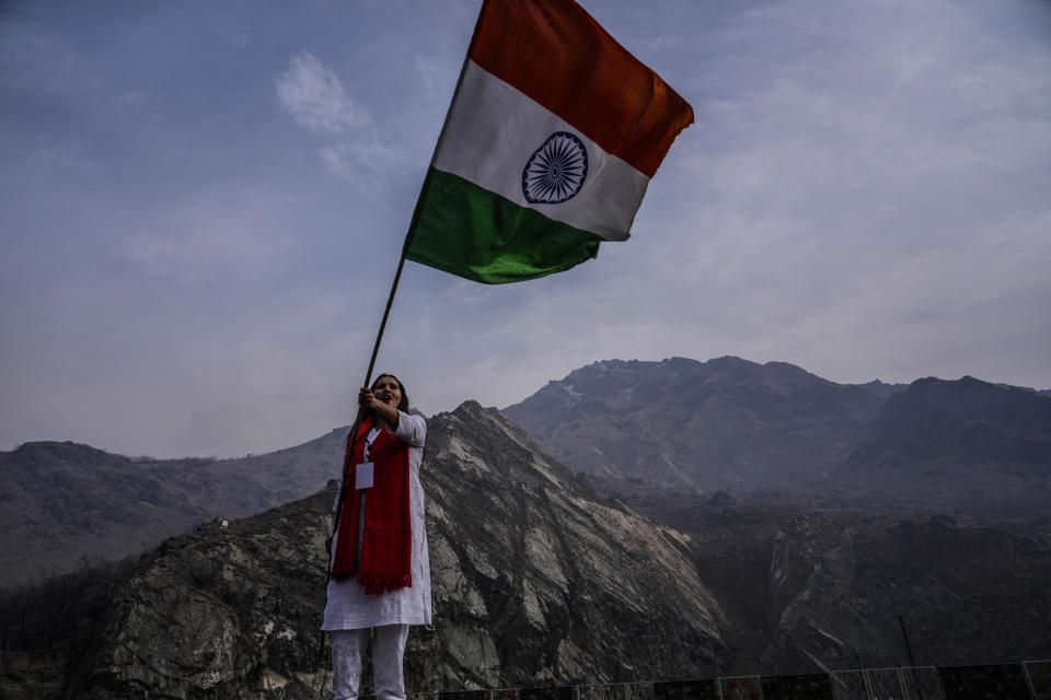 A supporter waves the Indian flag as India's opposition Congress party leader Rahul Gandhi and other leaders, walk during a 5-month-long "Unite India March," in Srinagar, Indian controlled Kashmir, Sunday, Jan. 29, 2023. The countrywide trek, that began from the southernmost tip of India, on Sept. 7., is expected to traverse 3,570 kilometers (2,218 miles) and cross 12 states before finishing in Indian-controlled Kashmir. (AP Photo/Mukhtar Khan)