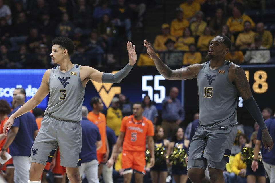 West Virginia forwards Tre Mitchell (3) and Jimmy Bell Jr. (15) high-five during the second half of an NCAA college basketball game against Auburn on Saturday, Jan. 28, 2023, in Morgantown, W.Va. (AP Photo/Kathleen Batten)