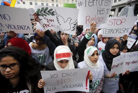 A girl (bottom C) holds a placard during a protest called "Not in my name" of Italian muslims against terrorism, in downtown Milan, Italy, November 21, 2015. The placard read: "I say no to violence". REUTERS/Alessandro Garofalo