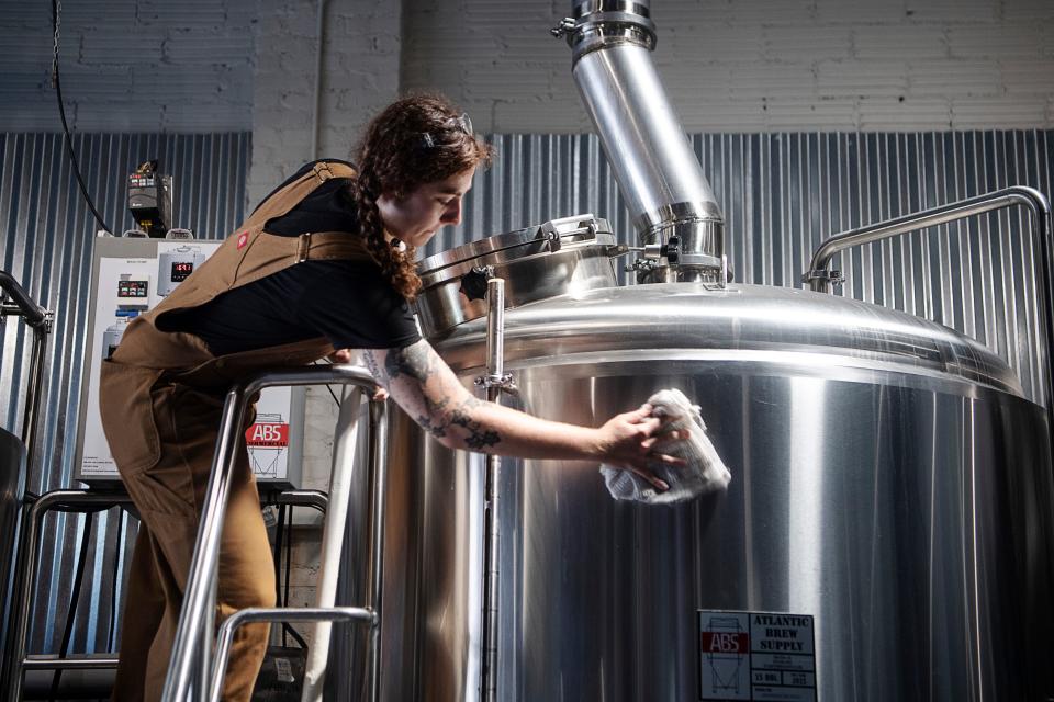 Brewer technician Sasha Bynum polishes a brew kettle at Terra Nova Beer Co. May 11, 2023.