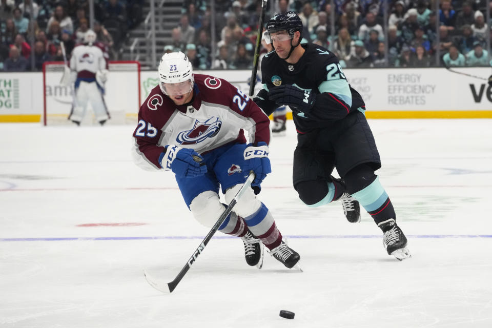 Colorado Avalanche right wing Logan O'Connor (25) breaks away from Seattle Kraken defenseman Vince Dunn (29) to gain possession before scoring during the second period of an NHL hockey game Tuesday, Oct. 17, 2023, in Seattle. (AP Photo/Lindsey Wasson)