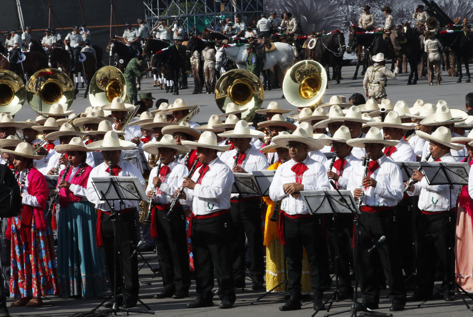 Musicians prepare to take part in a parade marking the 109th anniversary of the Mexican Revolution, in Mexico City, Wednesday, Nov. 20, 2019. More than a 1,000 participants dressed in time period clothing are expected to act out historical scenes. (AP Photo/Marco Ugarte)