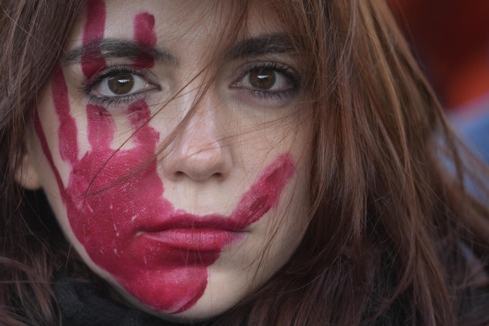 A woman attends a demonstration on the occasion of International Day for the Elimination of Violence against Women, in Milan, Italy, Saturday, Nov.25, 2023. (AP Photo/Luca Bruno)