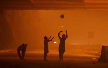 Girls play with a balloon under a flyover amidst the heavy smog in New Delhi, November 6, 2016. REUTERS/Adnan Abidi