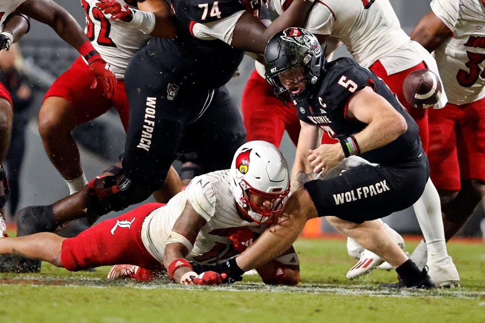 Louisville's Cam'Ron Kelly forces North Carolina State quarterback Brennan Armstrong (5) to fumble the ball during the second half of an NCAA college football game in Raleigh, N.C., Friday, Sept. 29, 2023. (AP Photo/Karl B DeBlaker)