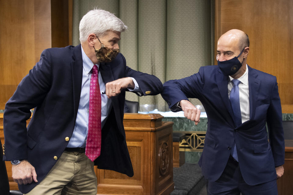 Sen. Bill Cassidy, R-La., left, elbow bumps Labor Secretary Eugene Scalia before a Senate Finance Committee hearing on "COVID-19/Unemployment Insurance" on Capitol Hill in Washington on Tuesday, June 9, 2020. (Caroline Brehman/CQ Roll Call/Pool via AP)