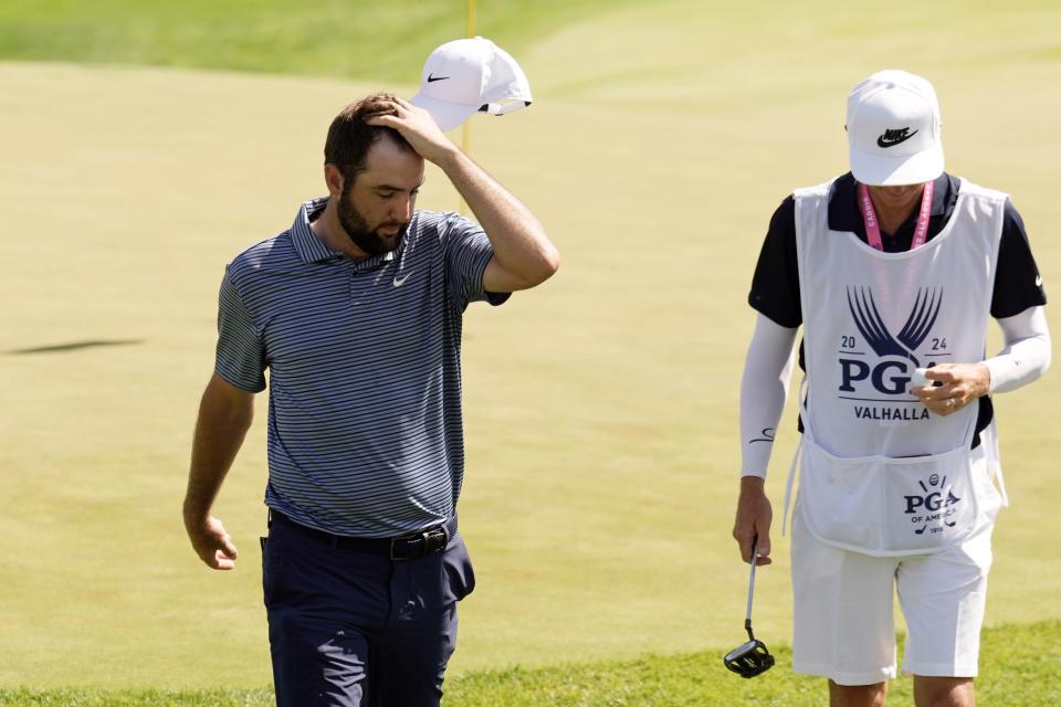 Scottie Scheffler and his caddie walk off the 18th green after the final round of the PGA Championship golf tournament at Valhalla Golf Club in Louisville, Ky. May 19, 2024.