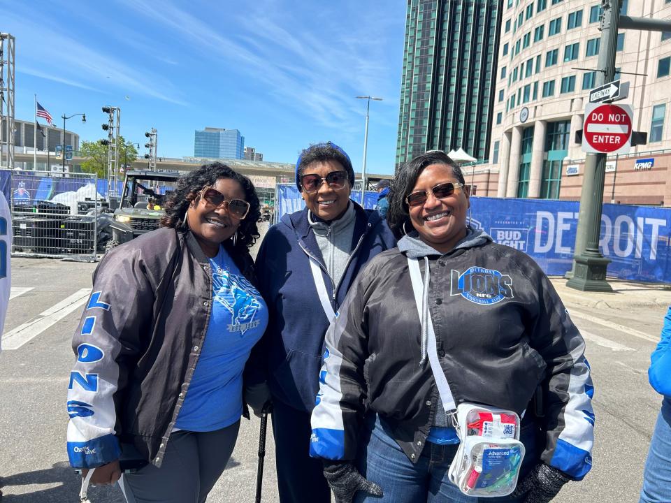Felicia Hodges (right), 47 of Detroit, stands with her mother and sister at Hart Plaza in line to take a photo with the Lions' helmet. She said she was looking forward to seeing the Dan Campbell fortune teller.