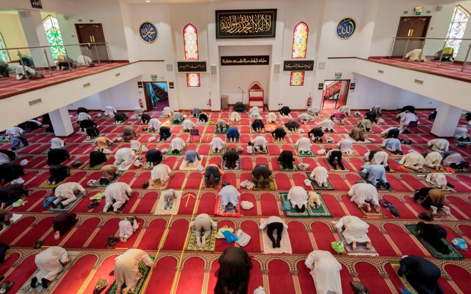 Worshippers observe social distancing at the Bradford Central Mosque on the first day of Eid, in Bradford, West Yorkshire, one of the areas where new measures have been implemented to prevent the spread of coronavirus. Stricter rules have been introduced for people in Greater Manchester, parts of East Lancashire, and West Yorkshire, banning members of different households from meeting each other indoors - Danny Lawson/PA