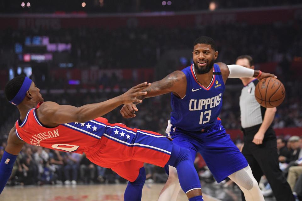 Philadelphia 76ers guard Josh Richardson, left, goes down as Los Angeles Clippers guard Paul George tries to drive past him during the first half of an NBA basketball game Sunday, Mar. 1, 2020, in Los Angeles. (AP Photo/Mark J. Terrill)