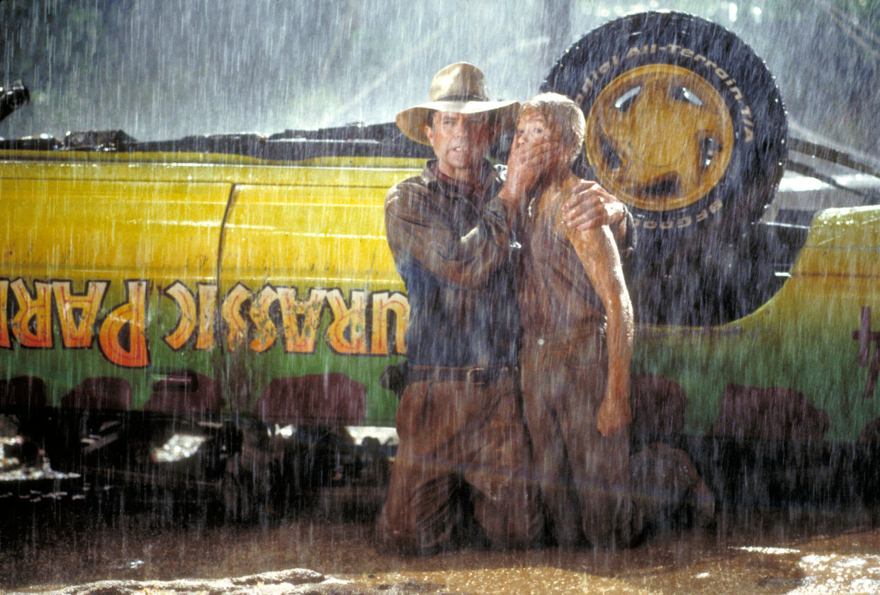 Actor Sam Neill as Dr. Alan Grant and Ariana Richards as Lex try to avoid the attention of a Tyrannosaurus Rex in a scene from the film 