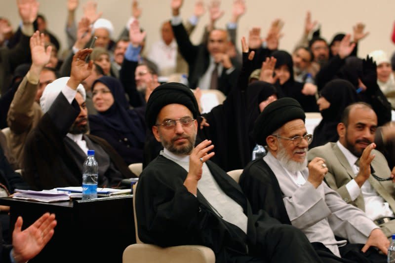 Members of the Iraqi Transitional National Assembly raise their hands to vote on an April 17, 2005, resolution during the assembly session in Baghdad, Iraq. On April 28, 2005, a Shiite-led Cabinet was approved by Iraq's National Assembly for its first freely elected government. File Photo by Wathiq Khuzaie/UPI