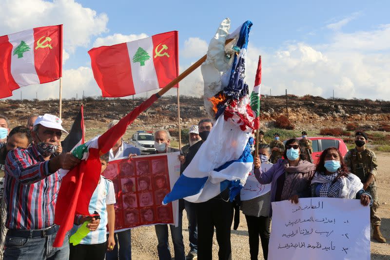 Demonstrators burn Israeli and American flags as they protest against talks on disputed maritime borders with Israel, in Naqoura, near the Lebanese-Israeli border