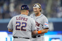 Houston Astros third baseman Grae Kessinger (16) laughs with first base coach Omar Lopez (22) after flying out against the Toronto Blue Jays during the third inning of a baseball game in Toronto on Wednesday, June 7, 2023. (Andrew Lahodynskyj/The Canadian Press via AP)