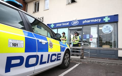 Police officers stand outside Boots pharmacy, near to the Barcroft Medical Centre in Amesbury - Credit: Yui Mok /PA
