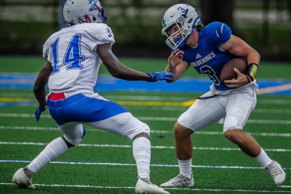 Wellington quarterback Ryan Anthony (3) jukes against the Pahokee Blue Devils in the season opener in high school football action on Friday, August 27, 2021, in Wellington, Fla. The Blue Devils won 28-21.