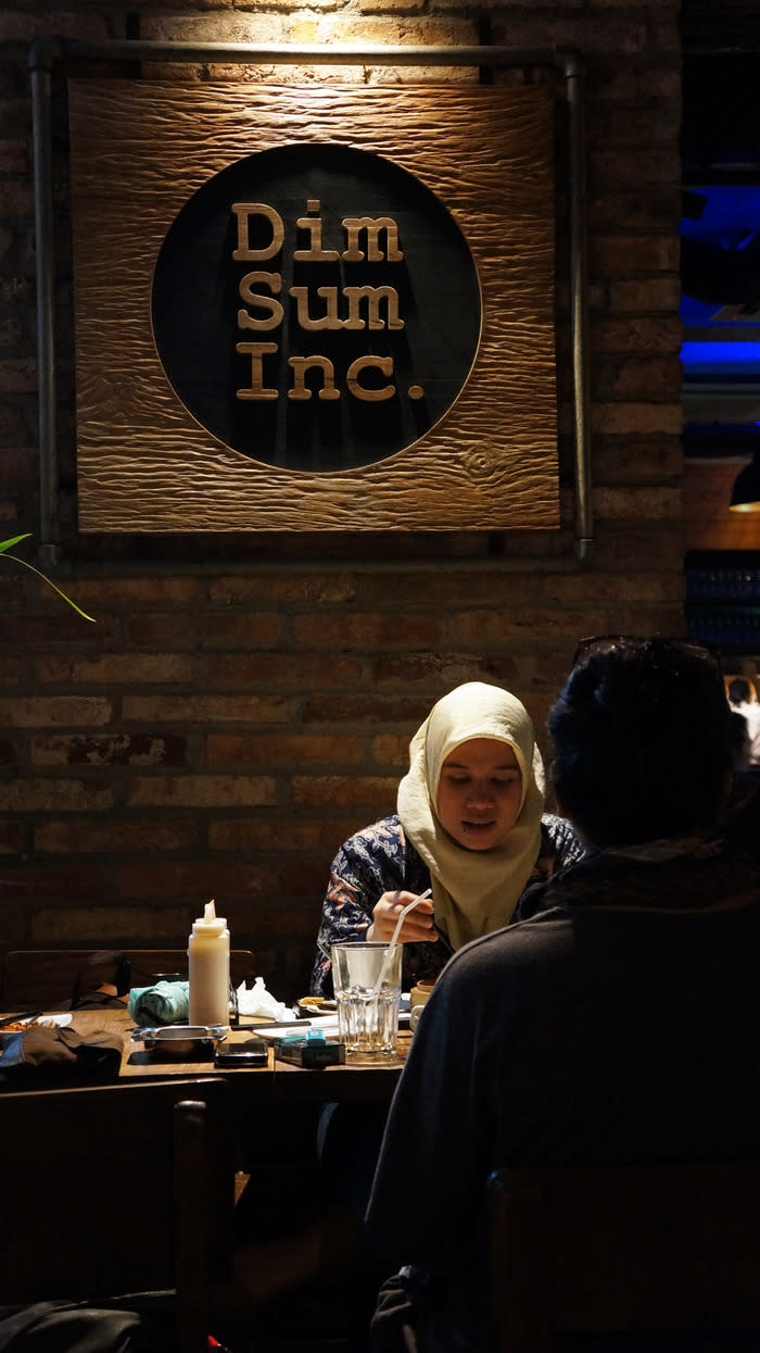 Chat all night: A woman enjoying her meal while chatting with her friend at the Dim Sum Inc restaurant. (