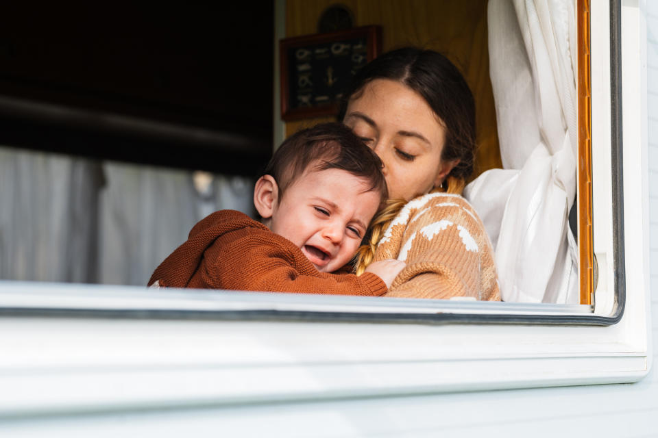 A woman is comforting her crying baby