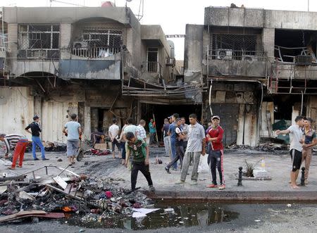 People gather at the site of car bomb in New Baghdad, July 22, 2015. REUTERS/Khalid al-Mousily