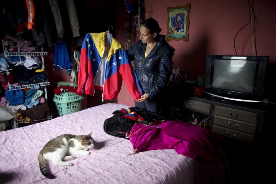 Judith Perez, mother of Karen Palacios, shows the jacket that her daughter wore many times during her performances, in Karen's bedroom in Los Teques in the outskirts of Caracas, Venezuela, Tuesday, July 16, 2019. Karen Palacios who plays the clarinet and was cut from the National Philharmonic for criticizing the government, and who was detained for 6 weeks, was released today. (AP Photo/Ariana Cubillos)