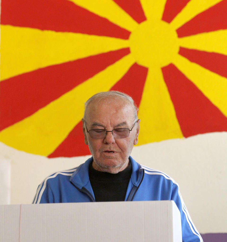 A man looks at his ballot behind a voting booth at a polling station, during the presidential elections in Skopje, North Macedonia, Sunday, April 21, 2019. North Macedonia holds the first round of presidential elections on Sunday, seen as key test of the government following deep polarization after the country changed its name to end a decades-old dispute with neighboring Greece over the use of the term "Macedonia". (AP Photo/Boris Grdanoski)