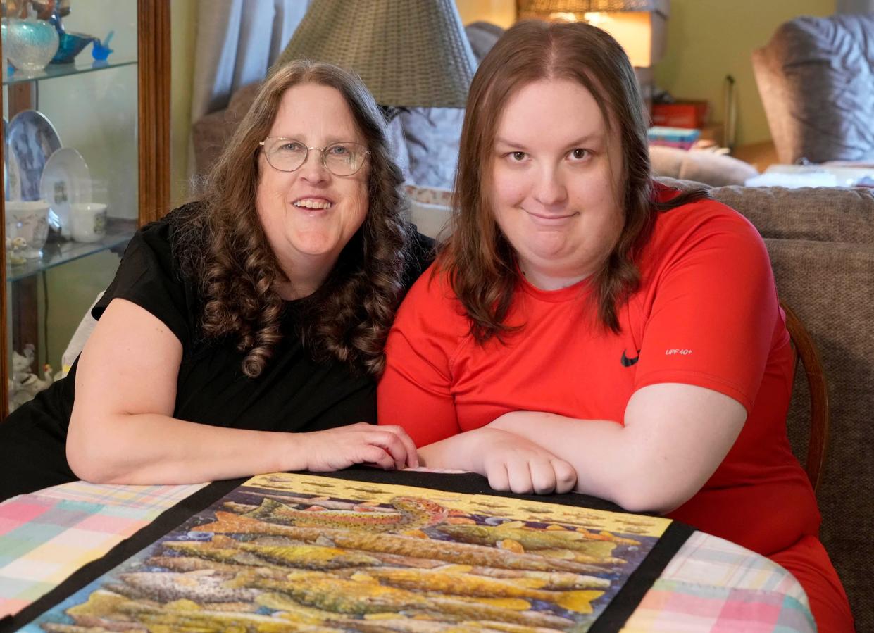 Alison Peetz and her son, Ben, sit before a 1000-piece puzzle they completed at their home in Brown Deer.