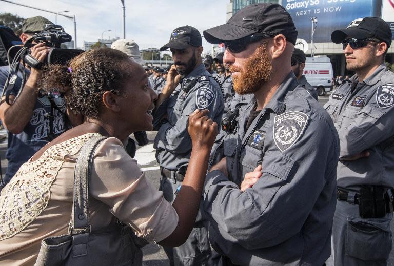 An Israeli woman from the Ethiopian community argues with Israeli security forces in the coastal city of Tel Aviv, on May 3, 2015, during a protest called by members of the Ethiopian community against alleged police brutality and discrimination