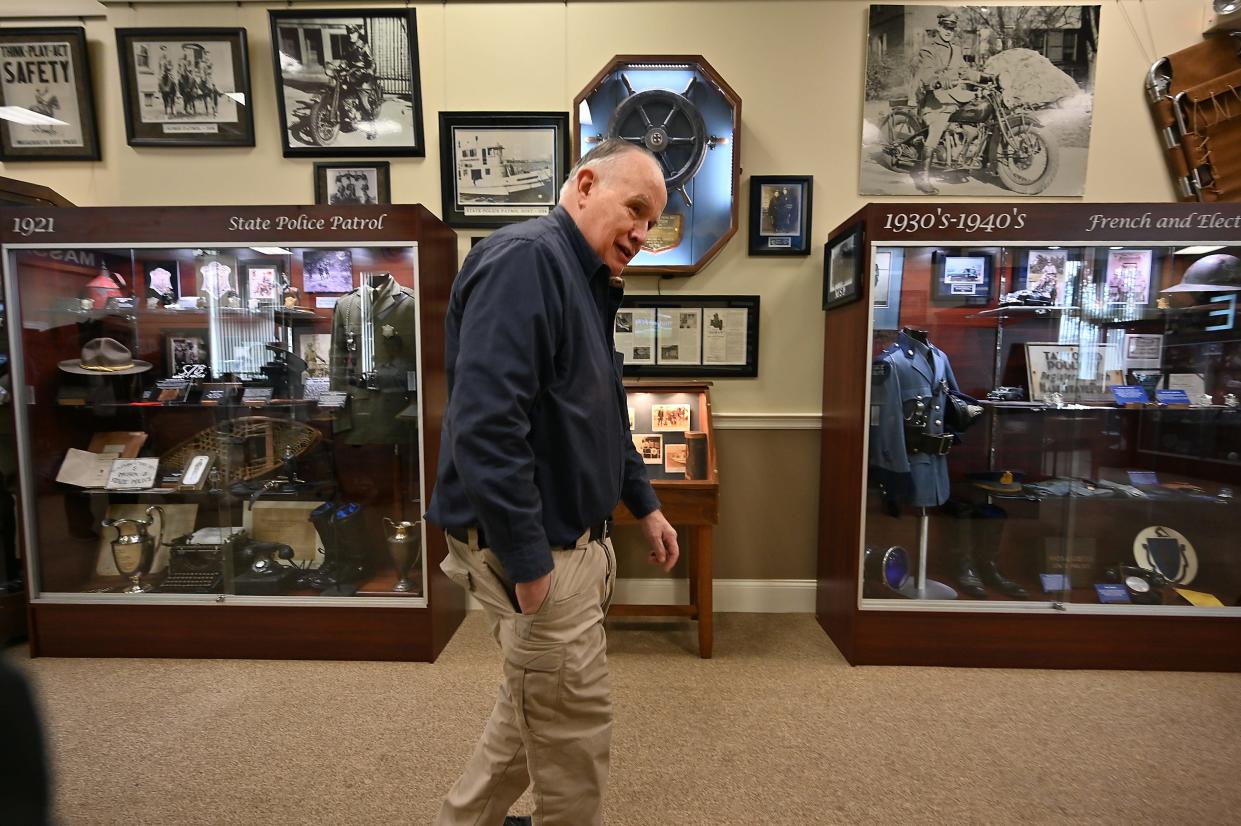 Steve Byron, president of the board of directors, walks through the Massachusetts State Police Museum and Learning Center.