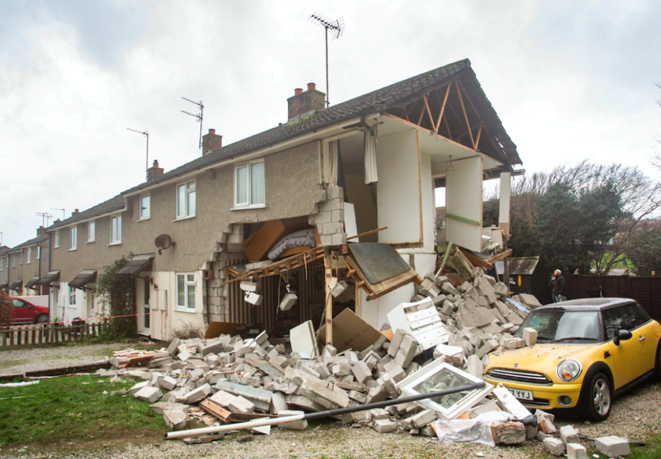 Bricks and mortar lie around the garden as the top of the house dangles perilously in the air. (SWNS)