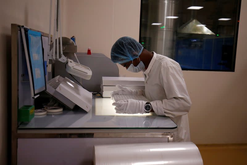 FILE PHOTO: An employee examines glass vials inside a manufacturing unit of Schott Kaisha in Jambusar