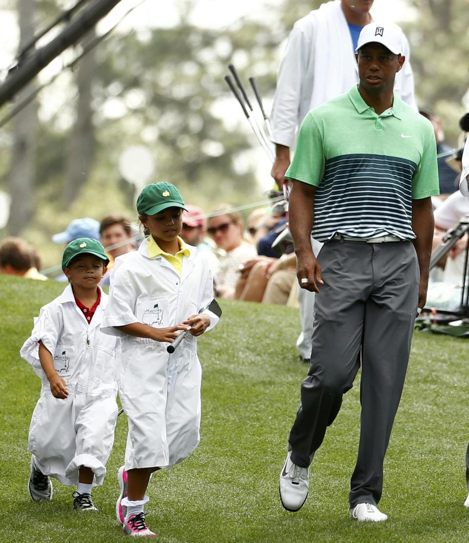 U.S. golfer Tiger Woods walks with his children Sam (C) and and Charlie down the first fairway during the par 3 event held ahead of the 2015 Masters at Augusta National Golf Course in Augusta, Georgia April 8, 2015. REUTERS/Mark Blinch