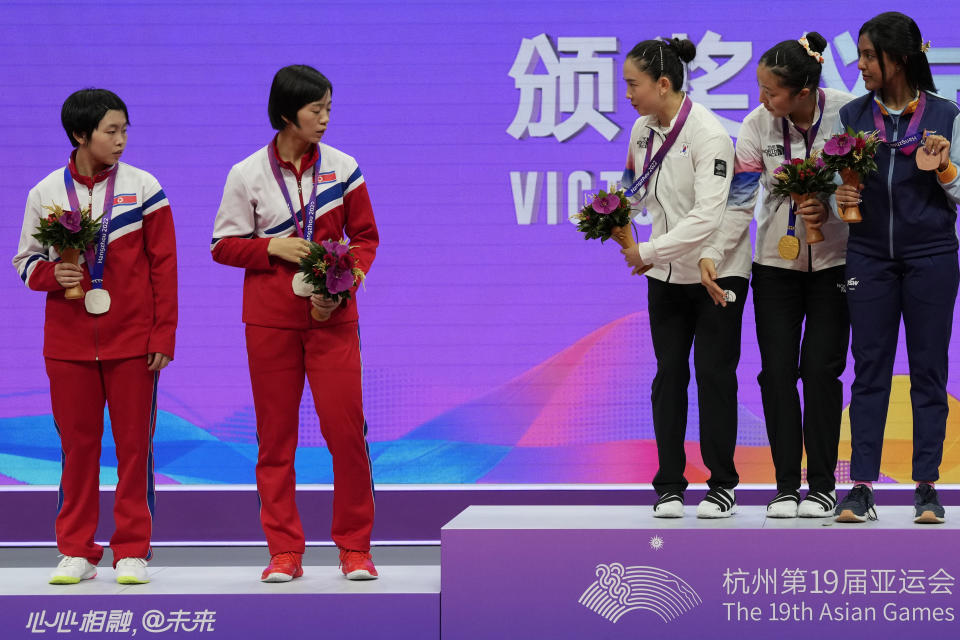 South Korea's Jeon Jihee, third from right and Shin Yubin invites North Korea's Cha Suyong, second from left and Pak Sugyong to join them on the podium during the awards ceremony for the Table Tennis Women's Doubles Final match for the 19th Asian Games in Hangzhou, Monday, Oct. 2, 2023. (AP Photo/Ng Han Guan)