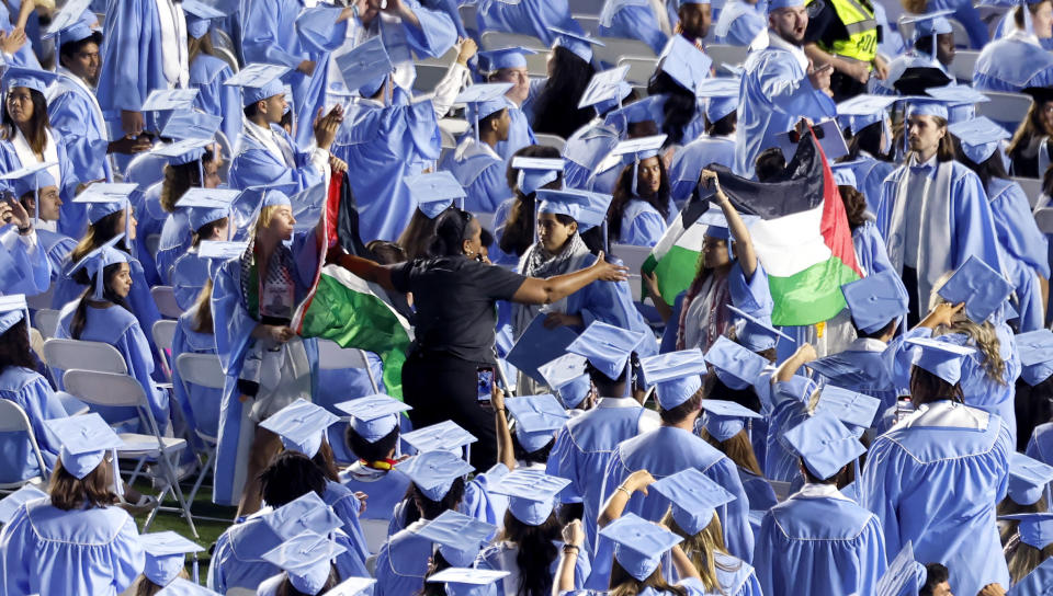 Palestinian flags are taken from protesters as they walk out of UNC Chapel Hill's commencement ceremonies at Kenan Stadium in Chapel Hill, N.C., Saturday, May 11, 2024. (Ethan Hyman/The News & Observer via AP)