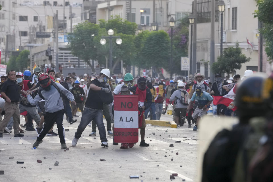 Anti-government protesters face off with the police in Lima, Peru, Tuesday, Jan. 24, 2023. Protesters are seeking the resignation of President Dina Boluarte, the release from prison of ousted President Pedro Castillo, immediate elections and justice for demonstrators killed in clashes with police. (AP Photo/Martin Mejia)