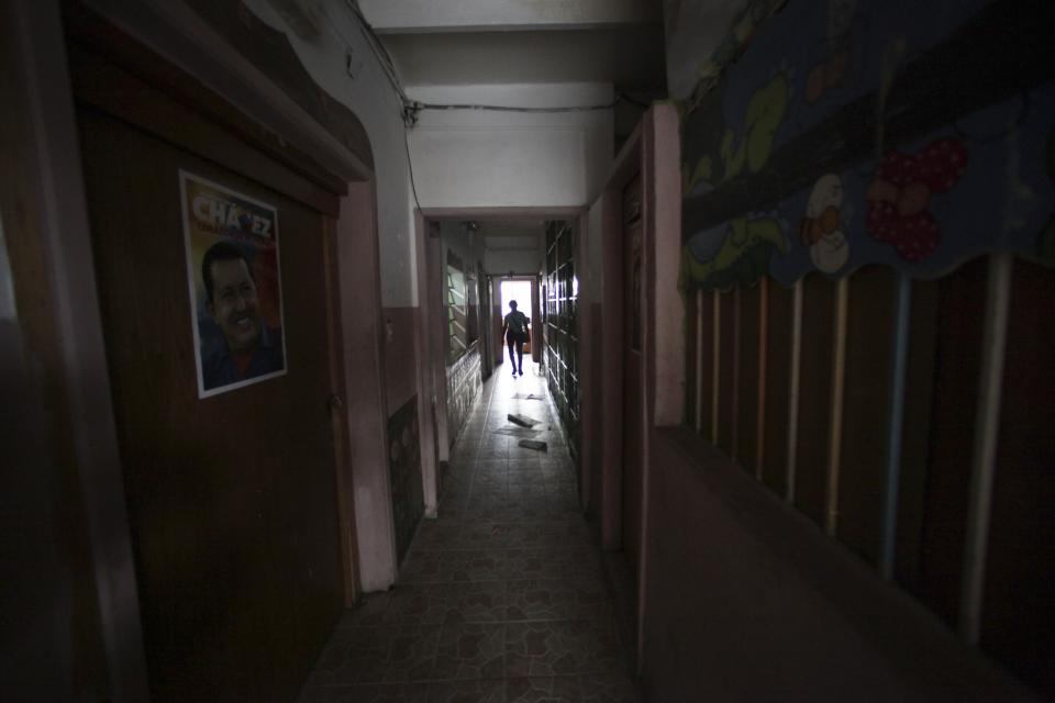 In this Sept. 27, 2012 photo, a woman walks in a hallway inside what was once a school and is now a government provided shelter for families who have lost their homes due to flooding, in Caracas, Venezuela. Fear of every stripe, like the loss of government housing like this one, permeates the intensely polarized election campaign, with many votes to be decided based not on the candidates' promises but rather on what worries people most. Chavez has continuously warning of chaos and the dismantling of the generous welfare state he built if he is voted out of office in the Oct. 7 vote. (AP Photo/Fernando Llano)