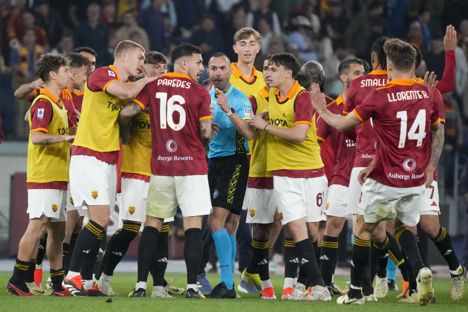 Roma players argue with referee Marco Guida, center, at the end of a Serie A soccer match between Roma and Lazio, at Stadio Olimpico, in Rome, Italy, Saturday, April 6, 2024. (AP Photo/Gregorio Borgia)