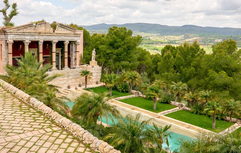 A temple Incorporating ancient architectural fragments overlooks the sprawling property.