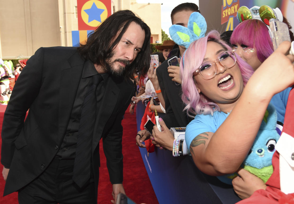 Keanu Reeves, left, takes a selfie with a fan as he arrives at the world premiere of "Toy Story 4" on Tuesday, June 11, 2019, at the El Capitan in Los Angeles. (Photo by Chris Pizzello/Invision/AP)