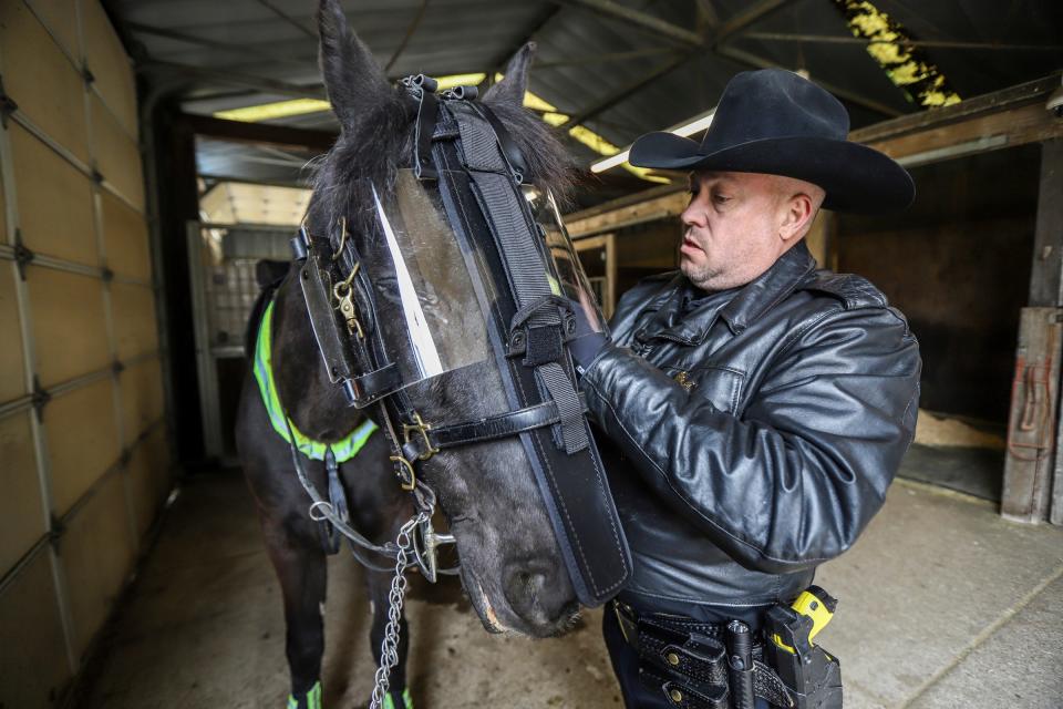 Deputy Michael Dennis, of the mounted unit, dresses his horse, Ace, in preparation to cover security during the NFL draft and NFL Draft Experience at the Wayne County Sheriff’s mounted unit in Livonia, Mich., on Wednesday, April 24, 2024.