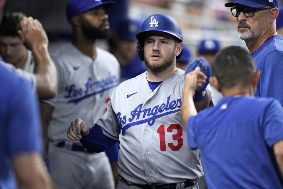 Los Angeles Dodgers' Max Muncy (13) is congratulated by teammates after he scored on a ground rule double by Kiké Hernández during the fifth inning of a baseball game against the Miami Marlins, Thursday, Sept. 7, 2023, in Miami. (AP Photo/Wilfredo Lee)