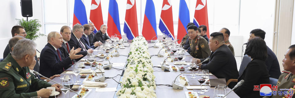 In this photo provided by the North Korean government, Russian President Vladimir Putin, fourth left, speaks at a welcome ceremony for North Korean leader Kim Jong Un, seated at fourth right, at the Vostochny cosmodrome outside the city of Tsiolkovsky, about 200 kilometers (125 miles) from the city of Blagoveshchensk in the far eastern Amur region, Russia, Wednesday, Sept. 13, 2023. Independent journalists were not given access to cover the event depicted in this image distributed by the North Korean government. The content of this image is as provided and cannot be independently verified. Korean language watermark on image as provided by source reads: "KCNA" which is the abbreviation for Korean Central News Agency. (Korean Central News Agency/Korea News Service via AP)