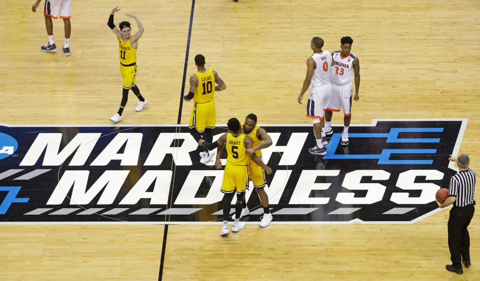 FILE - In this March 16, 2018, file photo, UMBC players celebrate their 74-54 win over Virginia in a first-round game in the NCAA men's college basketball tournament in Charlotte, N.C. This season's tournament, like all before them, would've been filled with dozens of legends in the making and diamonds in the rough--with teams that overcame adversity to get this far and superfans who inspired the country every bit as much as their team. (AP Photo/Chuck Burton, File)