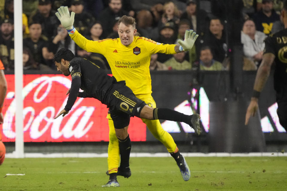 CORRECTS NAME OF PLAYER FROM DENIS BOUANGA TO CARLOS VELA - Los Angeles FC forward Carlos Vela collides with Houston Dynamo goalkeeper Steve Clark after being called for offsides during the first half in the MLS playoff Western Conference final soccer match Saturday, Dec. 2, 2023, in Los Angeles. (AP Photo/Marcio Jose Sanchez)