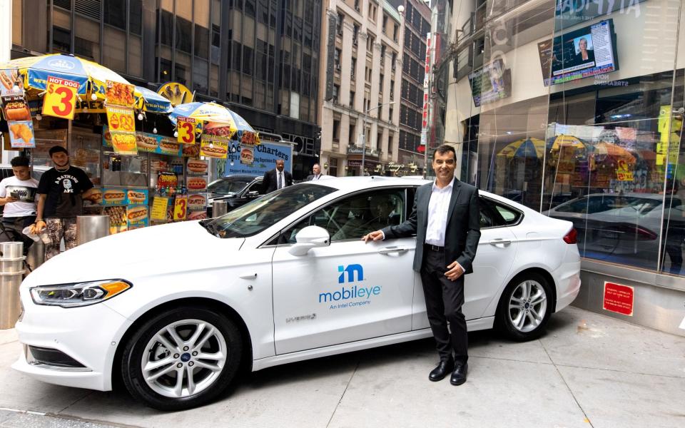 Mobileye's founder and chief executive Amnon Shashua with one of its driverless vehicles outside the Nasdaq in New York