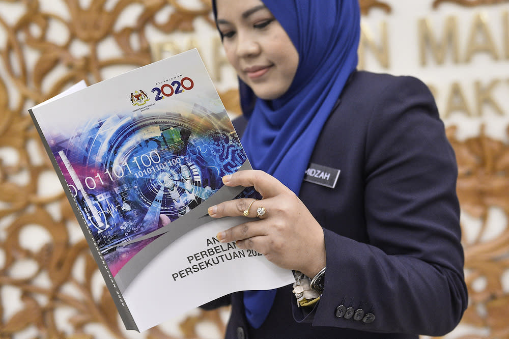 A woman holds copy of Budget 2020 after its tabling in Parliament October 11, 2019. — Picture by Miera Zulyana