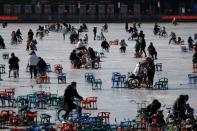 People wearing face masks following the coronavirus disease (COVID-19) outbreak skate on a frozen lake