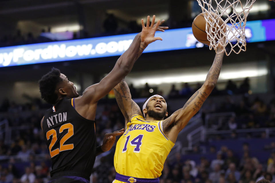 FILE - In this March 2, 2019, file photo, Los Angeles Lakers forward Brandon Ingram (14) shoots next to Phoenix Suns' DeAndre Ayton during an NBA basketball game in Phoenix. Two people familiar with the situation say the New Orleans Pelicans have agreed to trade six-time All-Star Anthony Davis to the Lakers for point guard Lonzo Ball, Ingram, shooting guard Josh Hart and three first-round draft choices. The people spoke to The Associated Press on condition of anonymity because the trade cannot become official until the new league year begins July 6. ESPN first reported the trade. (AP Photo/Rick Scuteri, File)