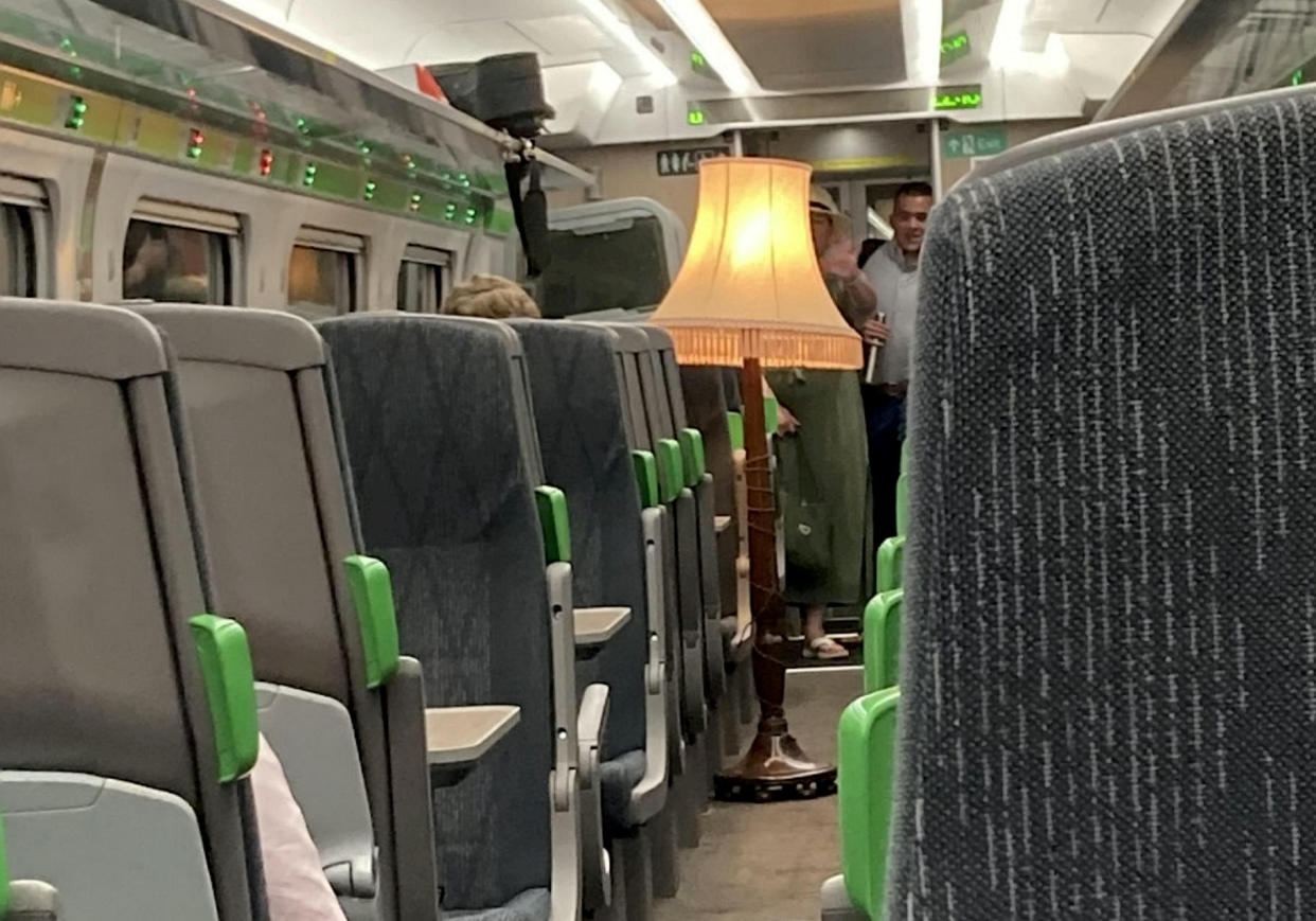 The man boarded a train and plugged in a giant old fashioned lamp in the middle of the aisle.  (SNWS)