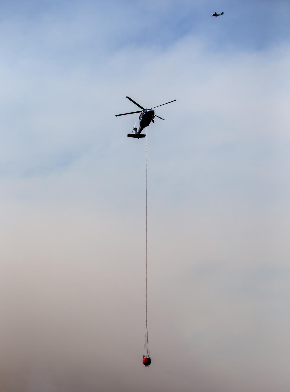 A helicopter flies over a wildfire in Ruidoso, N.M., Tuesday, June 18, 2024. Thousands of residents fled their homes as a wildfire swept into the mountain village of Ruidoso in southern New Mexico. (AP Photo/Andres Leighton)