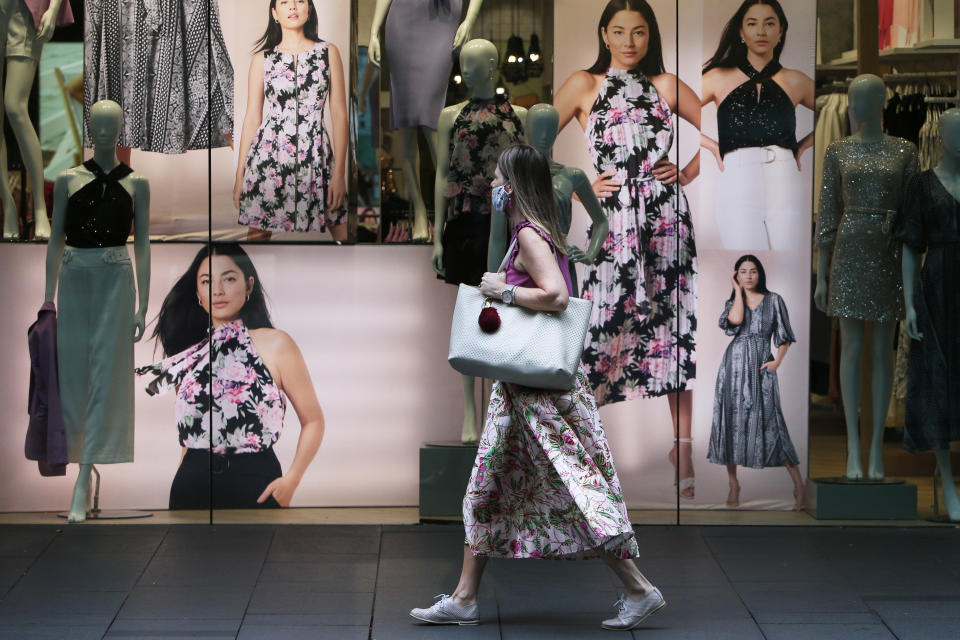 A female shopper walks past a retail store. (Source: Getty)